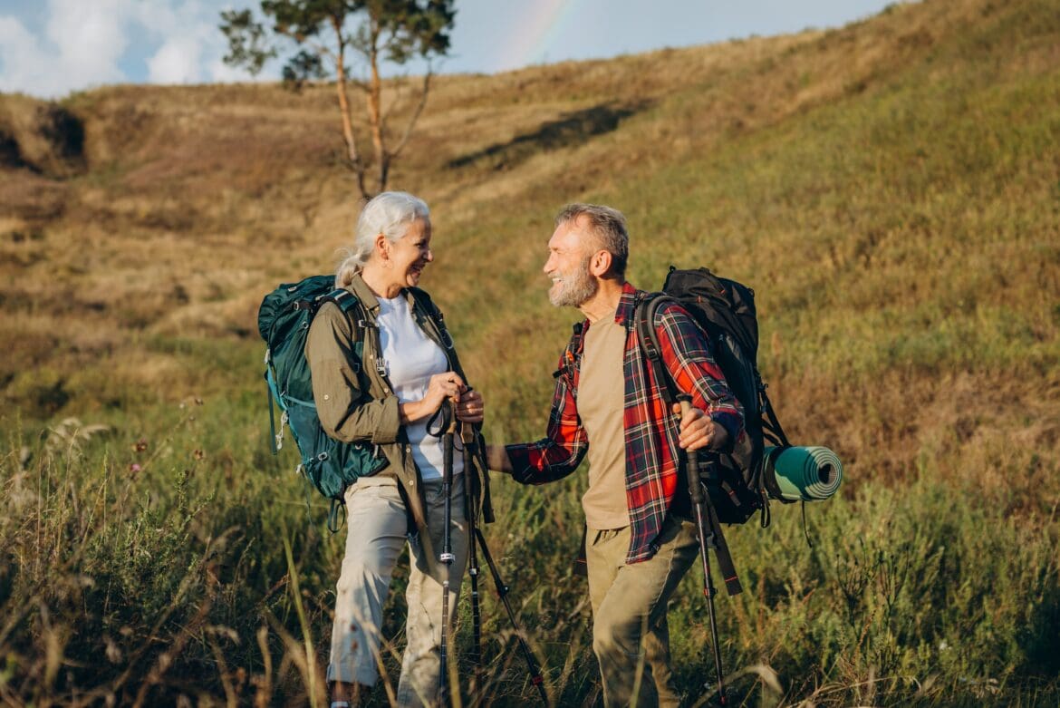 Older couple hiking in the countryside representing retirement lifestyle and state pension planning